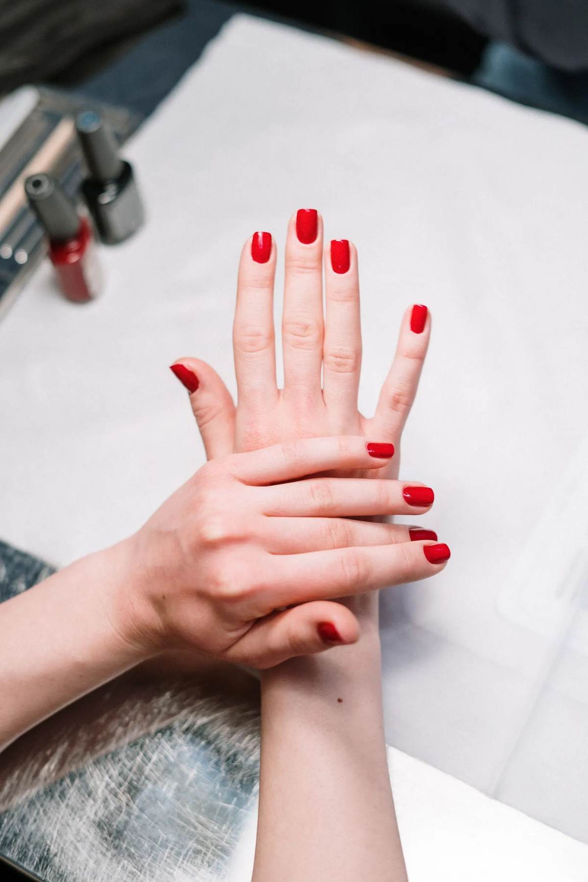 Fresh red polish on manicured nails at Ultimate Nails