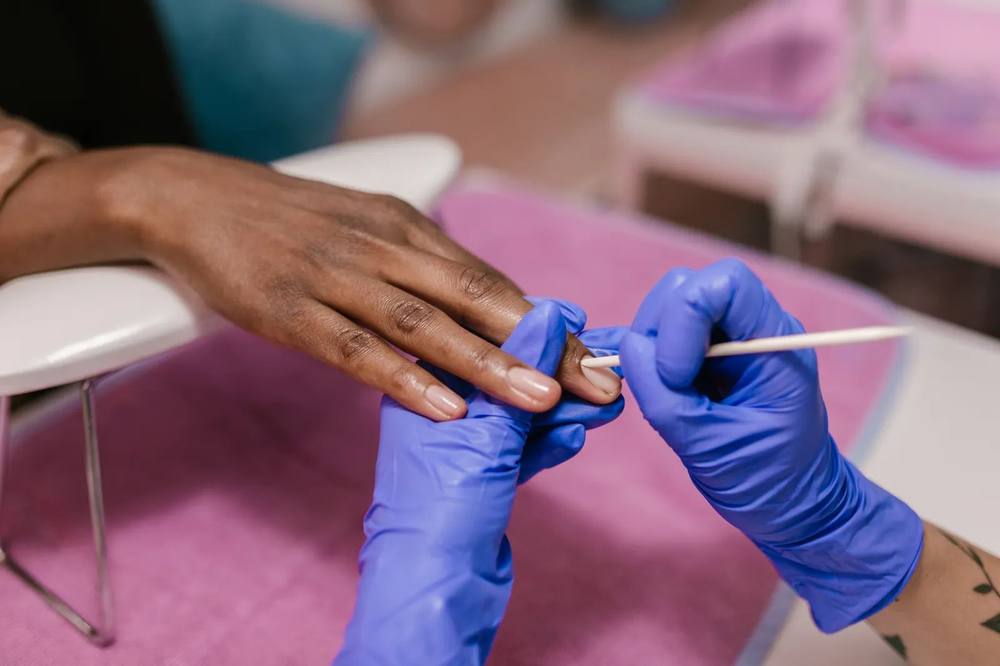 A technician at work on a client&rsquo;s nails